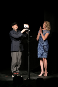 Pamela Tatge smiles and claps as Sidi Larbi Cherkaoui accepts the Jacob's Pillow Dance Award.