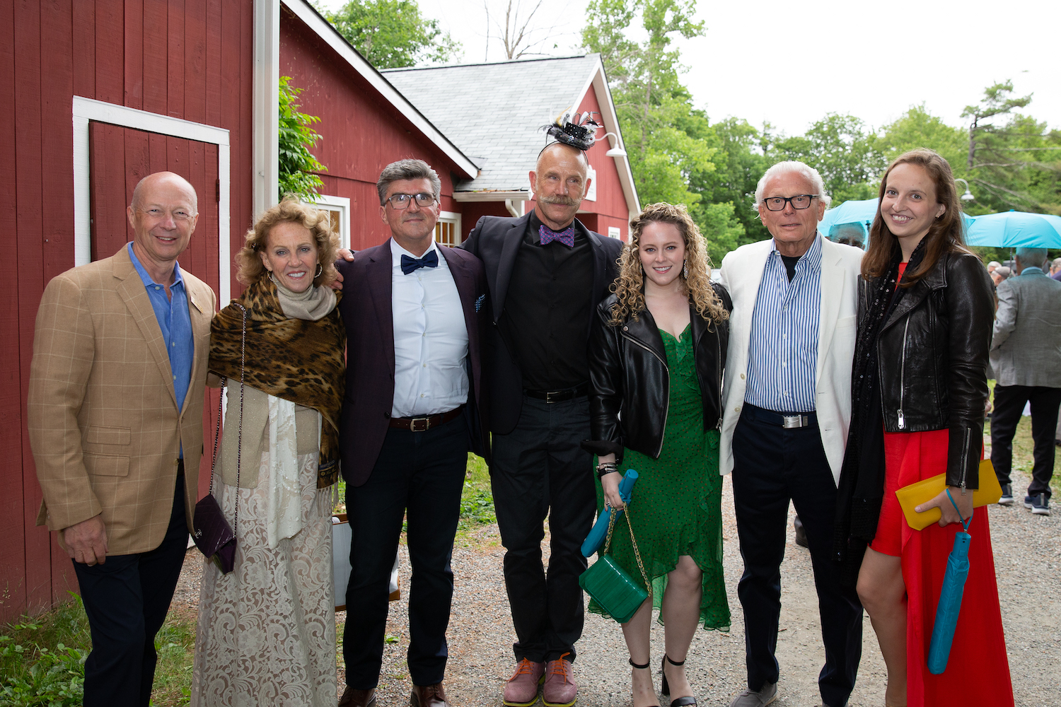 A group of party-goers smile for the camera while outdoors.