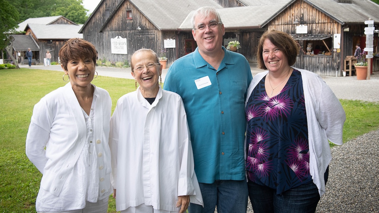 Four elderly members of Jacob's Pillow stand smiling for the camera