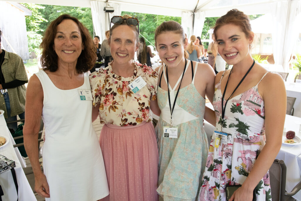 4 women stand smiling for the camera at the 2022 School Sponsor Luncheon. 2 are School Sponsors and 2 are dancers in the Musical Theatre Program.