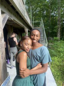 Two dancers embrace backstage.