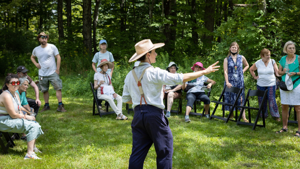 Adam Weinert faces a group of people and gestures to the side as he gives a tour of Jacob's Garden