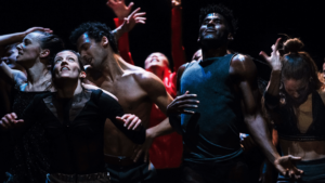 Martha Graham Dance Company dancers dimly lit in a large clump all in different gestures.