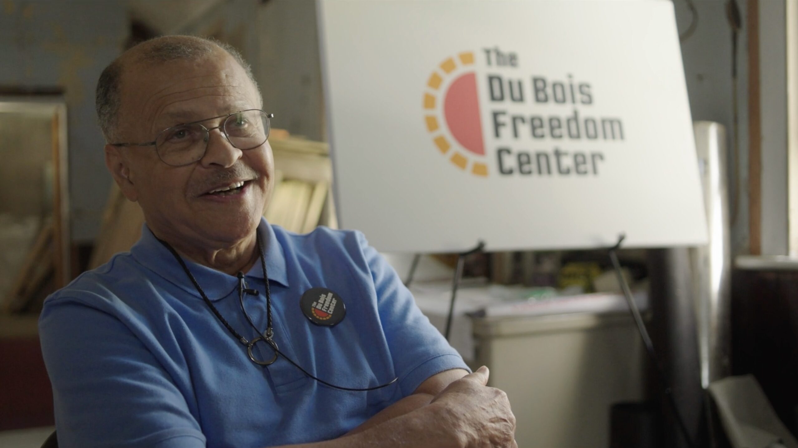 David Levering Lewis smiles in front of a sign for the DuBois Freedom Center
