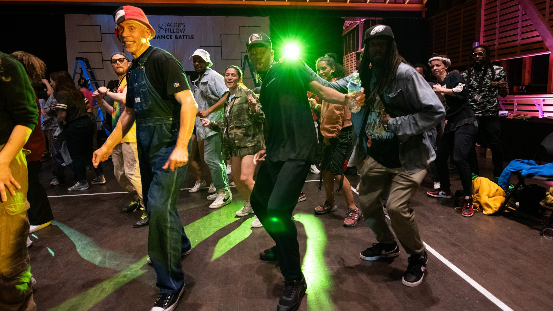 Group of people in a lively room doing a line dance.