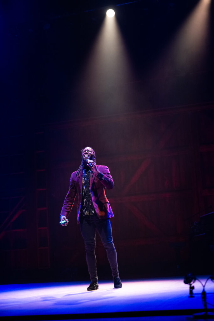Photo of a man under a spotlight singing in the Ted Shawn Theatre.