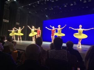 dutch national ballet dancers dance after William Forsythe's vertiginous thrill of exactitude. There are four female dancers wearing neon yellow tutus and two male dancers wearing red unitards